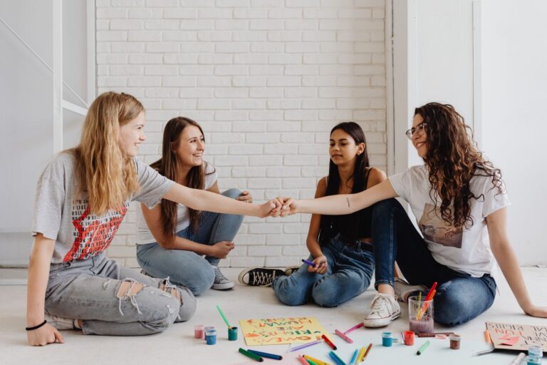 Groep meiden maakt samen posters tijdens de Meiden Club van BOT