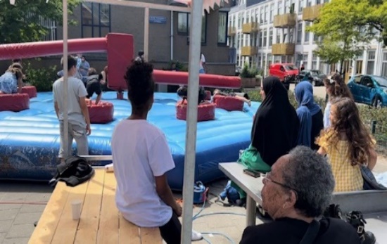 Bezoekers kijken naar de opblaasbare stormbaan op het Ruth Firstplein